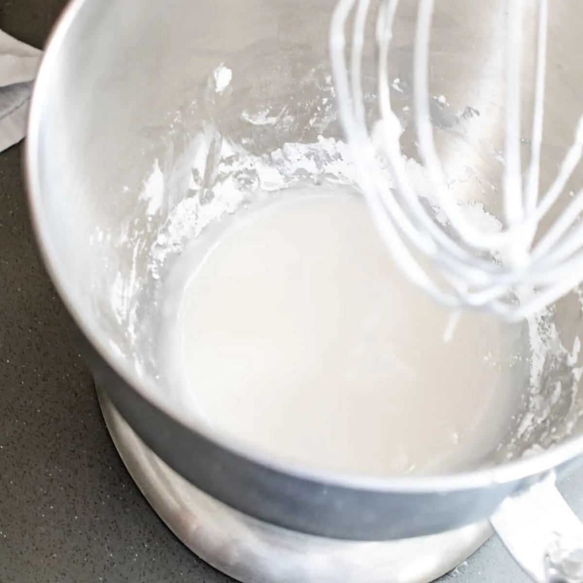 Mixing bowl filled with powdered sugar and corn syrup mixture. 