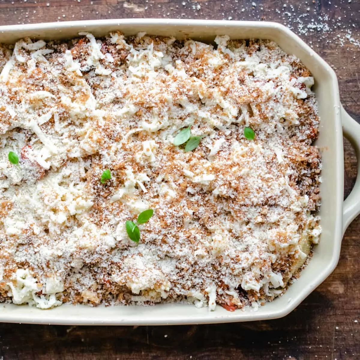 Stuffed pasta shells with mozzarella, bread crumbs and basil leaves on top.