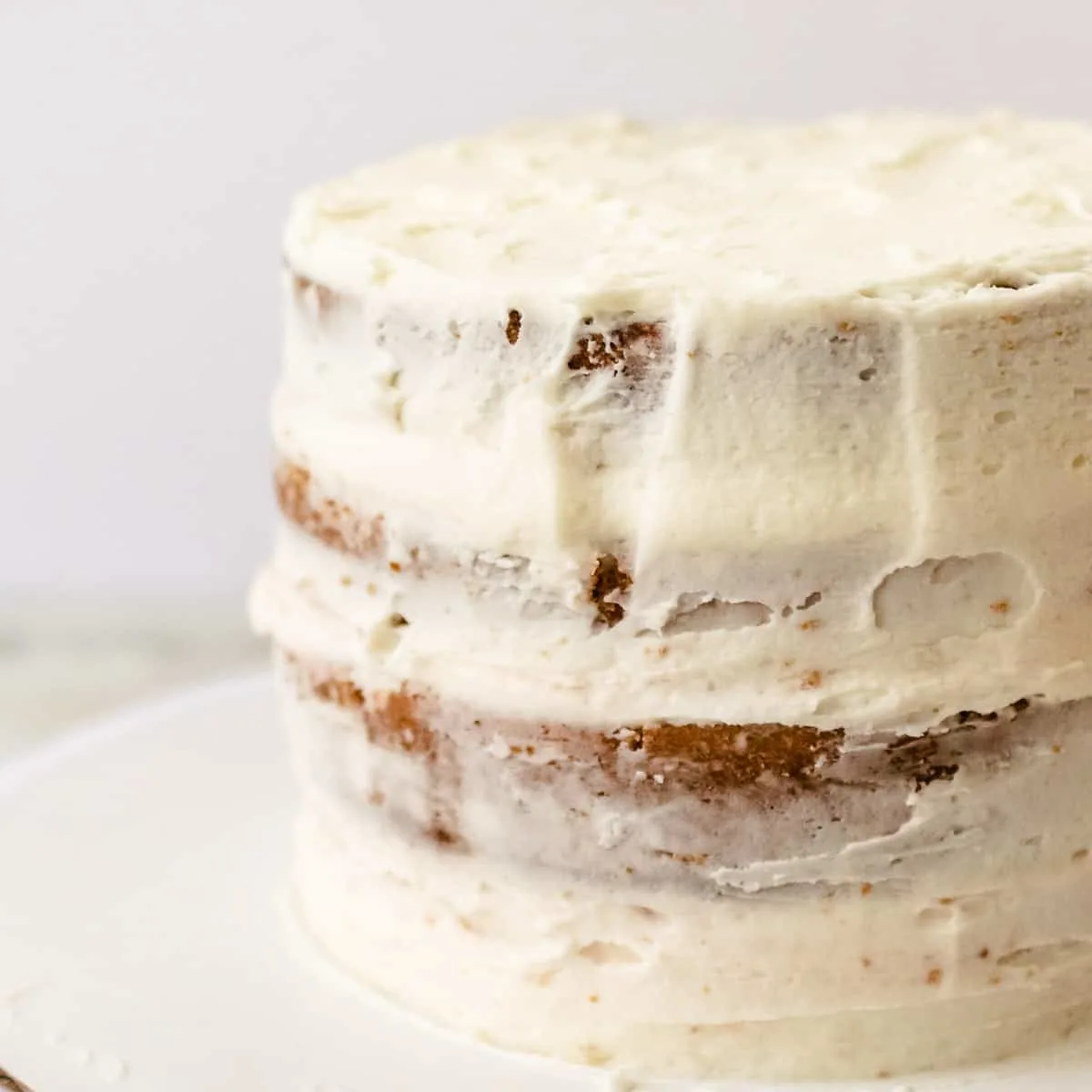 Four layers of strawberry layer cake with a white crumb coat of frosting. 