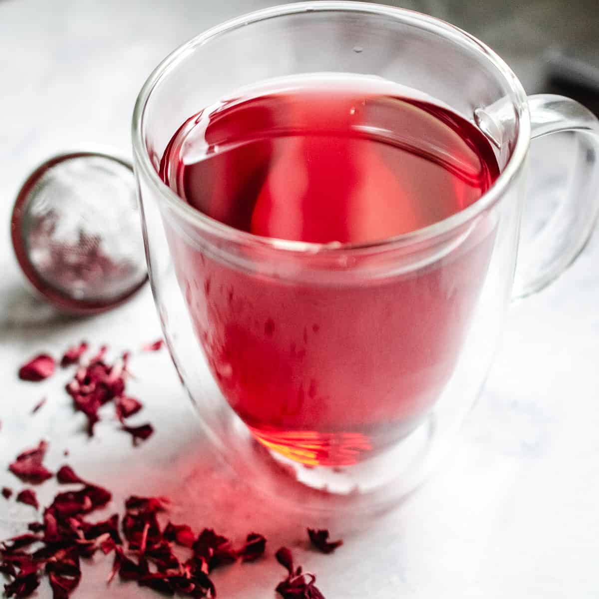 A glass mug of hot hibiscus tea.
