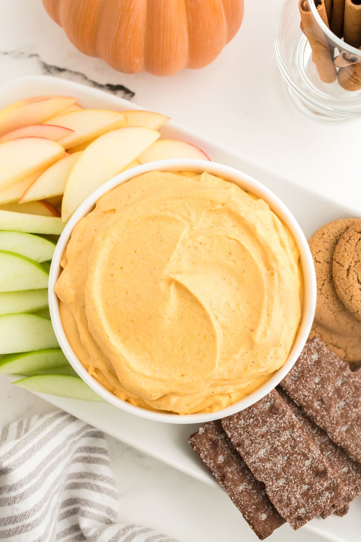 A bowl of freshly mixed pumpkin dip with the dipping assortment around it.
