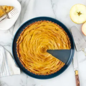 an apple tart with a slice taken out for serving