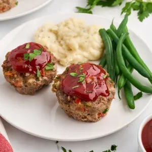 mini meatloafs made in muffin pan served with mashed potato and green beans