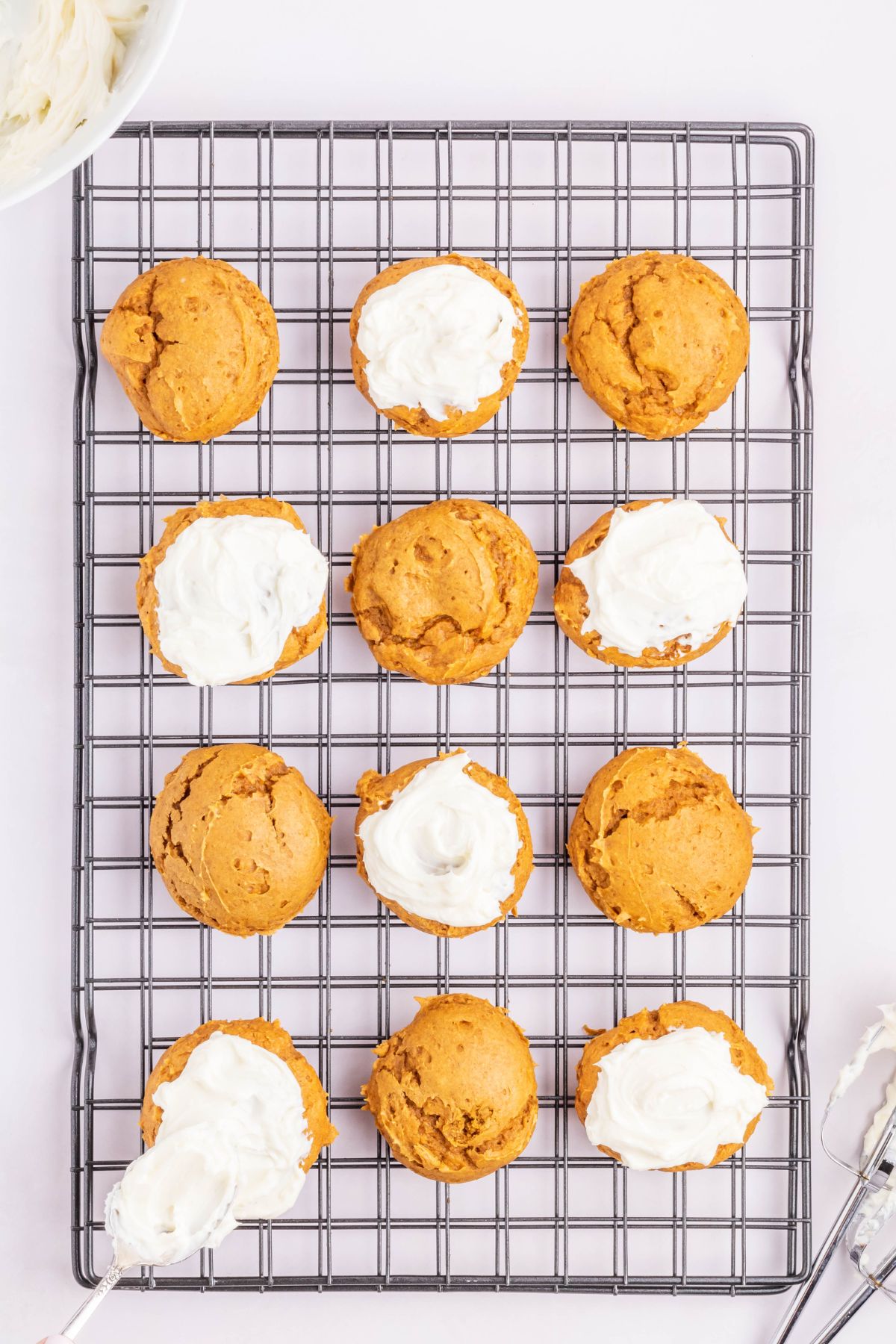 Cream cheese frosting on top of pumpkin cookies.