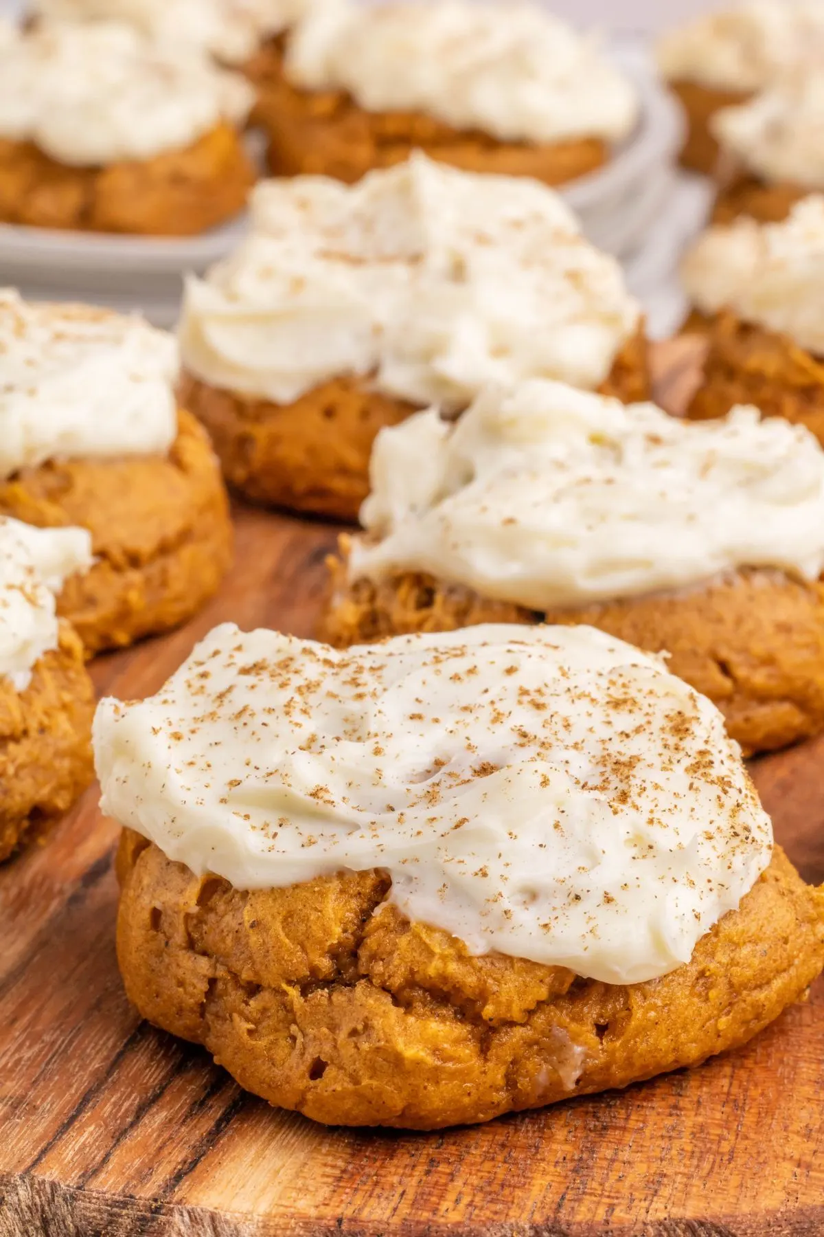 A few soft Pumpkin Cookies with cream cheese frosting on a serving platter.