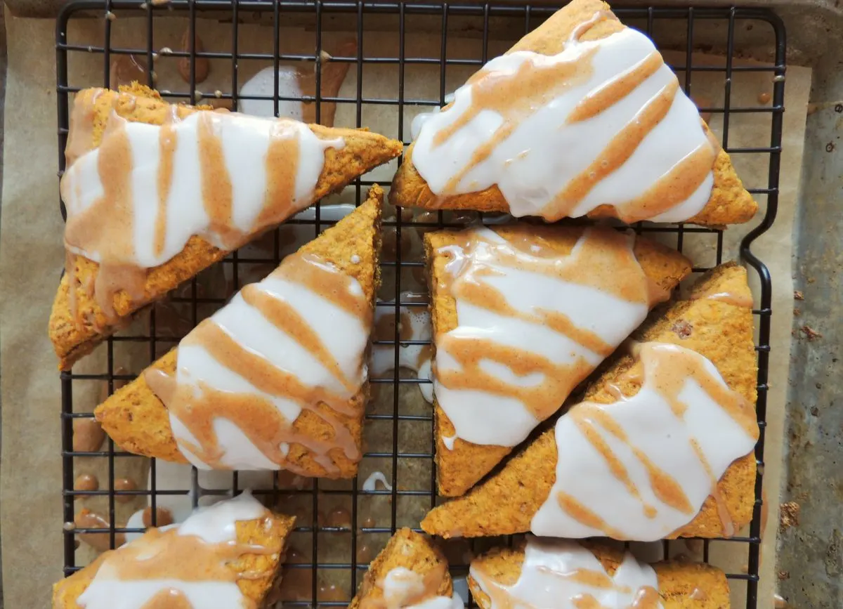 A few glaze pumpkin scones on a rack.