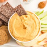 Looking down on a bowl of creamy pumpkin dip with dippers surrounding it.