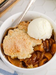 Looking down on a bowl of apple cobbler with a scoop of ice cream.