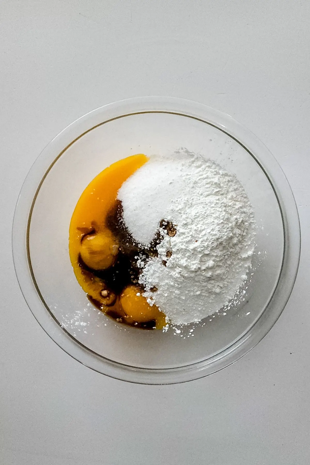 A mixing bowl with eggs, sugar, salt, and cornstarch.