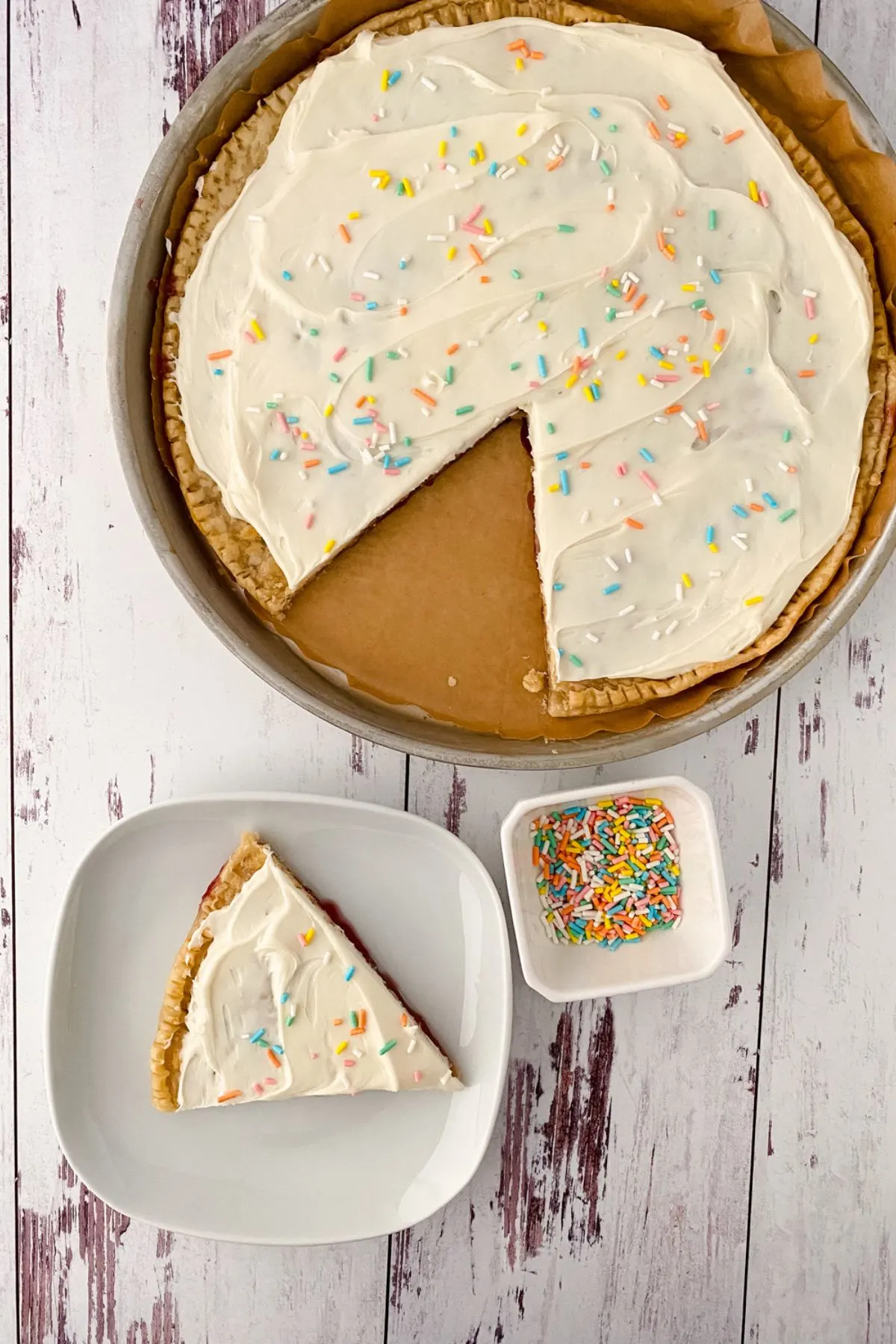 A piece of a Giant Poptart on a plate next to the rest of the big one.