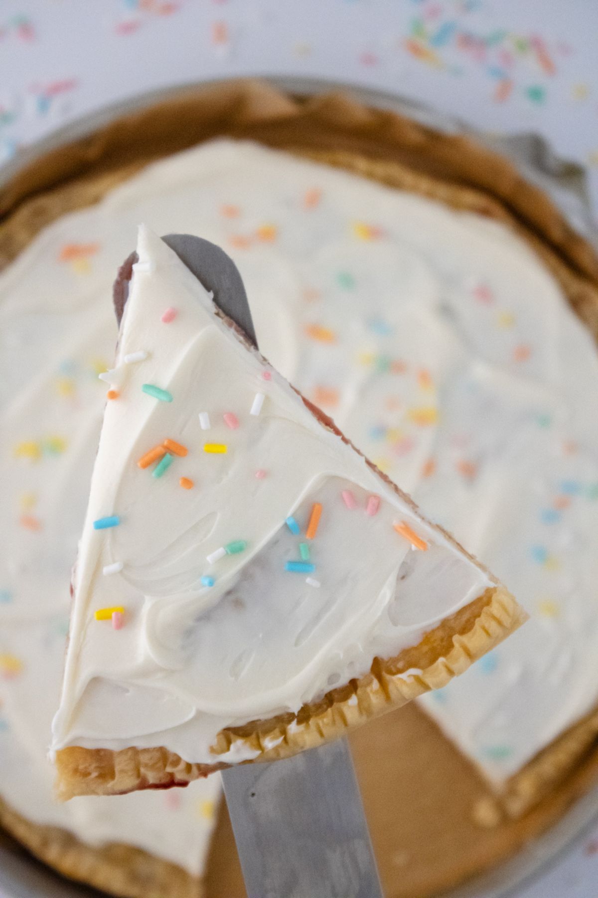A slice of a Giant Pop Tart being held above the rest of the pie.