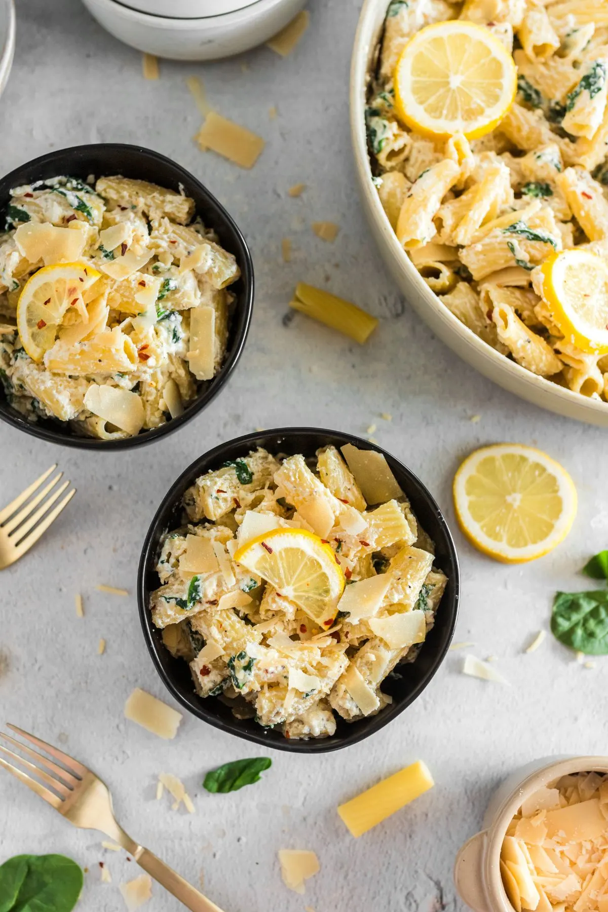 Looking down on two black bowls filled with Lemon Pasta with Ricotta Sauce.
