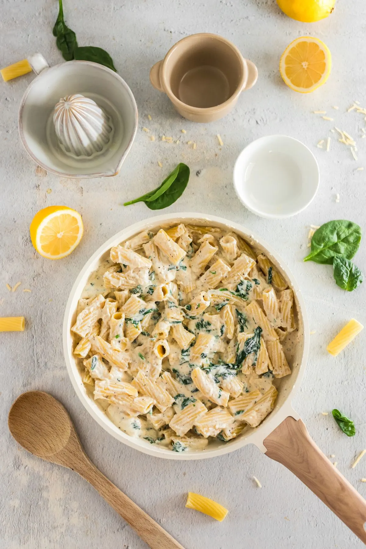 Pasta in a ricotta sauce with spinach in a skillet.