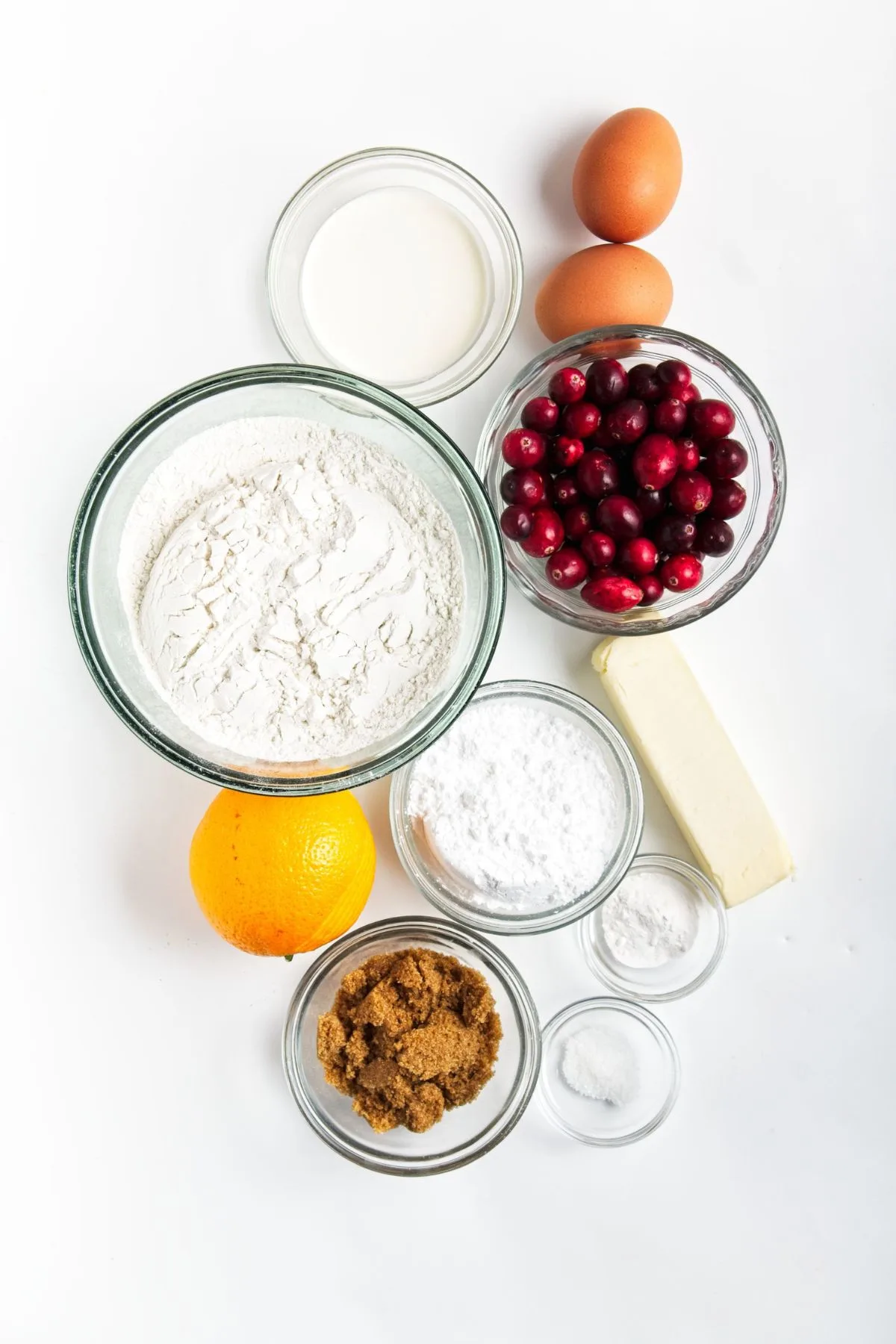 Cranberries, butter, flour, orange, baking powder, salt, heavy cream, eggs, powdered sugar, and orange juice.