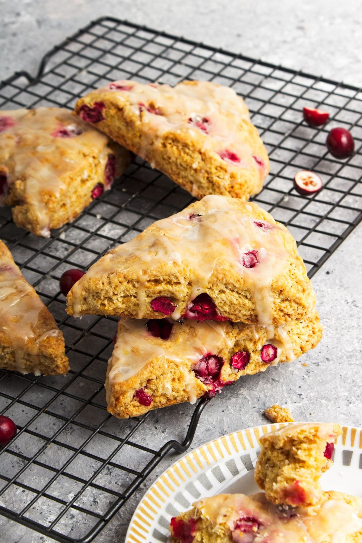 A few stacked Cranberry Orange Scones on a wire rack.