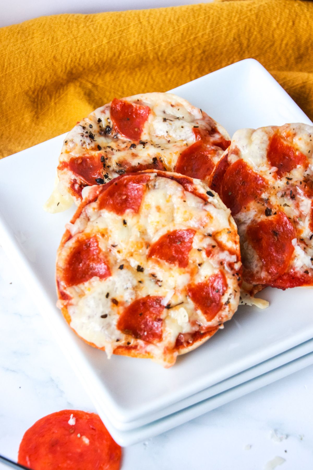 A few homemade Bagel Bite Pizzas on a plate.